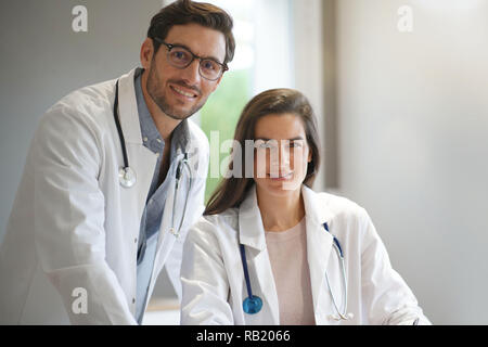 Young doctors in lab coats smiling Stock Photo