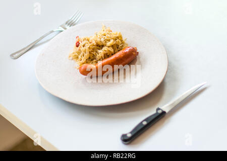 Cabbage with sausages in a plate on the table. Selective focus. Stock Photo