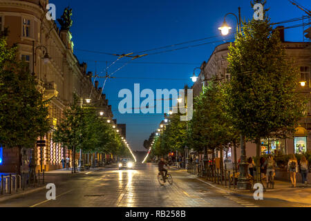 Vilnius, Lithuania - June 20th 2018 - Tourists and locals walking near a historical building in a early night in Vilnius Stock Photo
