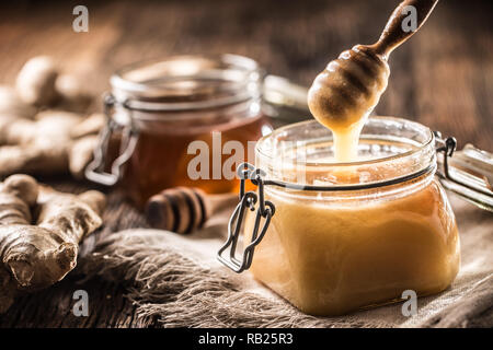 Honey in jars and  dipper on rustic oak table. Stock Photo