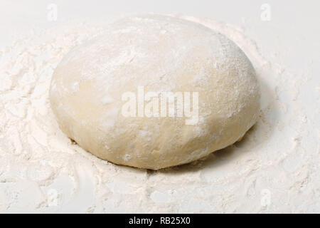 Raw fresh dough in flour on a white background Stock Photo