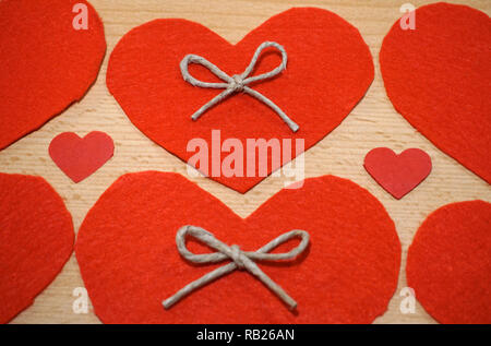 Love and Valentines Day background with handmade hearts from red felt on wooden background Stock Photo