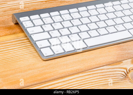 Business workplace with wireless keyboard on old natural wooden table background. Office desk with copy space Stock Photo