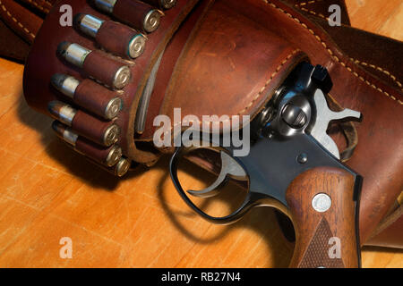 A Ruger Security Six revolver in a leather holster with a bandoleer of .357 magnum bullets. Stock Photo