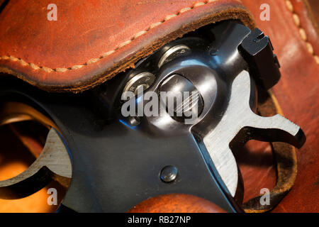 A Ruger Security Six revolver in a leather holster with a bandoleer of .357 magnum bullets. Stock Photo