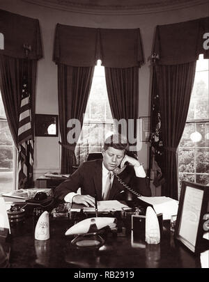 President John F. Kennedy addressing the AMVETS Convention in New York City by telephone from the Oval Office of the White House on August 23, 1962. Stock Photo