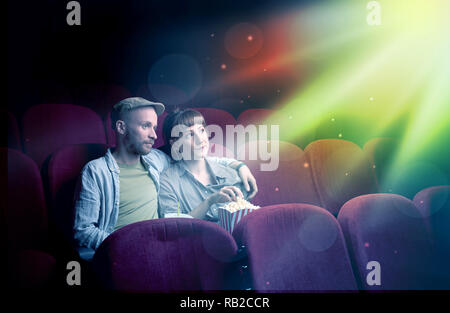 Teenager couple cuddling and watching the climax part of the movie Stock Photo