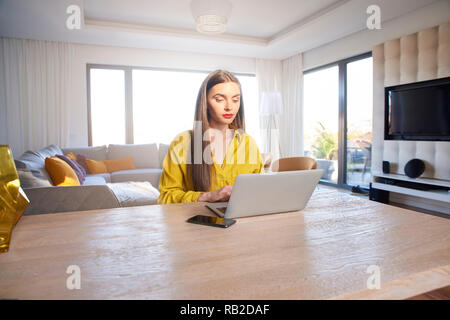 Shot of confident young woman using laptop while working from home. Home office. Stock Photo