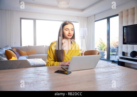 Shot of confident young woman using laptop while working from home. Home office. Stock Photo