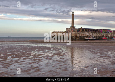 Reflection of Harbour Arm Pier in the wet sand at low tide with a creamy sky Stock Photo