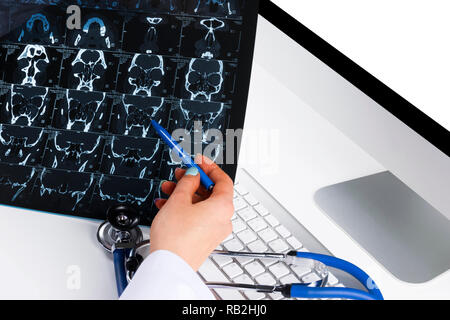 Doctor looking at computer tomography x-ray image, medicine doctor's working table with computer and stethoscope. Healthcare concept Stock Photo