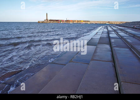 view across the water to the Harbour Arm from concrete steps Stock Photo