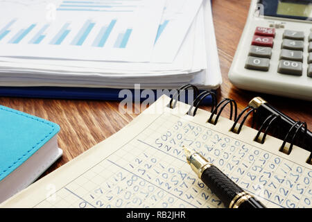 Financial figures in an accounting book and business analytical graphs. Stock Photo
