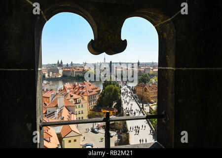 PRAGUE, CZECH REPUBLIC - JULY 2018: Aerial view of the Charles Bridge in Prague framed by a decorative stone arched window on top of the Lesser Town Br Stock Photo