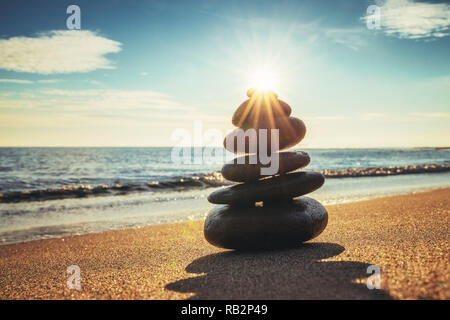 Stones balance on beach, sunrise shot. Zen meditation. Stock Photo