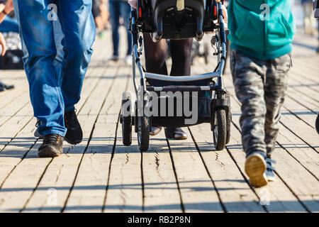 cropped image of family walking with baby carriage Stock Photo