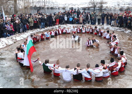 Zverino, Bulgaria. January 6, 2019: People perform the national dance 'Horo' in the icy waters of the river Iskar in the village of Zverino, during celebrations of the Epiphany day on 6 January 2019. Credit: GeorgiD/Alamy Live News Stock Photo