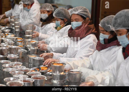 Hangzhou, China. 6th Jan, 2019. Volunteers pack Laba porridge just cooked at Lingyin Temple in Hangzhou, capital of east China, Jan. 6, 2019. Lingyin Temple started to make the traditional Laba porridge on Sunday, which was the first day of the 12th month of the Chinese lunar calendar, and will share it with local community for free. Credit: Huang Zongzhi/Xinhua/Alamy Live News Stock Photo