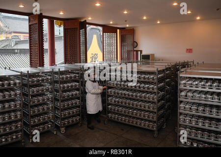 Hangzhou, China. 6th Jan, 2019. A volunteer shelves Laba porridge just cooked at Lingyin Temple in Hangzhou, capital of east China, Jan. 6, 2019. Lingyin Temple started to make the traditional Laba porridge on Sunday, which was the first day of the 12th month of the Chinese lunar calendar, and will share it with local community for free. Credit: Huang Zongzhi/Xinhua/Alamy Live News Stock Photo