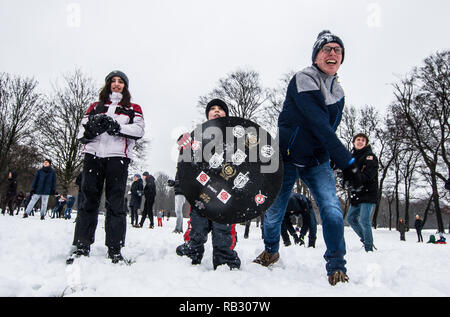 Munich, Bavaria, Germany. 6th Jan, 2019. Adult participants team up with a child holding a homemade shield as they launch snowballs at opposing teams. Hundreds of winter revelers in Munich, Germany hold a snowball fight in the famed English Garden. Over the past week, southern Germany and Austria experienced periods of heavy, sometimes prolonged snowfall with significant accumulations leading to difficult driving conditions and mass transit delays. Credit: Sachelle Babbar/ZUMA Wire/Alamy Live News Stock Photo