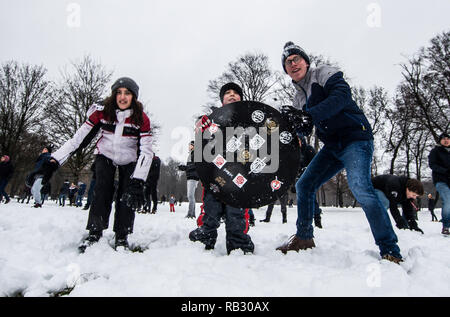 Munich, Bavaria, Germany. 6th Jan, 2019. Adult participants team up with a child holding a homemade shield as they launch snowballs at opposing teams. Hundreds of winter revelers in Munich, Germany hold a snowball fight in the famed English Garden. Over the past week, southern Germany and Austria experienced periods of heavy, sometimes prolonged snowfall with significant accumulations leading to difficult driving conditions and mass transit delays. Credit: Sachelle Babbar/ZUMA Wire/Alamy Live News Stock Photo
