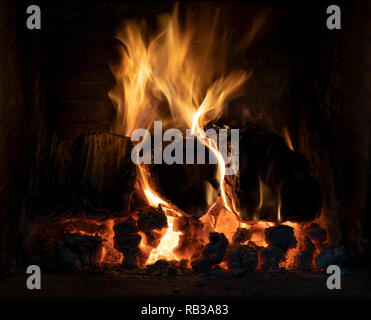 A blazing log fire in an open fireplace Stock Photo