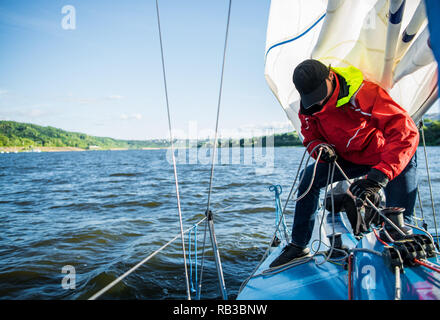 Young man working on sailing ship, active lifestyle, summer sport concept Stock Photo