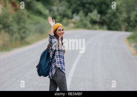 traveler woman smiling and waving hand on the road, summer holiday travelling Stock Photo