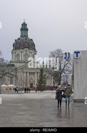 STOCKHOLM, SWEDEN - DECEMBER 29, 2018: City scene at Odenplan with Gustaf Vasa church people and entrance to commuter train and subway on December 29, Stock Photo