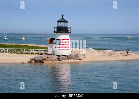 Brant Point lighthouse on Nantucket Island has an American flag wrapped arount the tower greeting visitors to this Masschusetts island. It is a favori Stock Photo