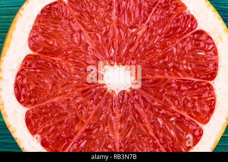Fresh half cut grapefruit on a blue wooden background, close up view Stock Photo