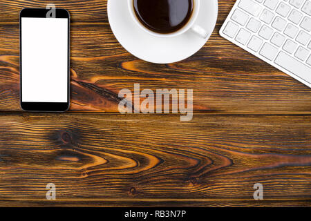 Office desk with copy space. Digital devices wireless keyboard, mouse and tablet computer with empty screen on burned  wooden table with cup of coffee Stock Photo