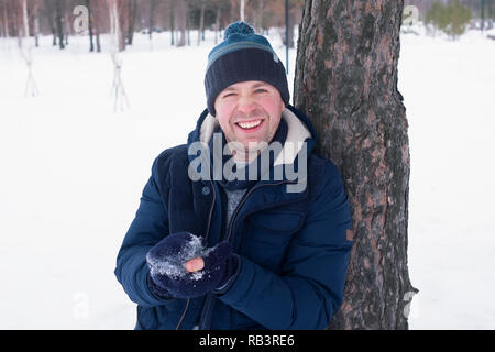 Outdoor portrait of smiling handsome man in coat and scurf. Casual winter fashion Stock Photo