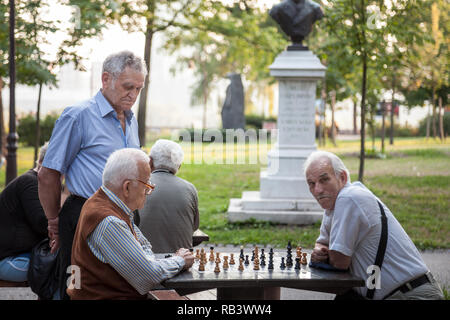 BELGRADE, SERBIA - JULY 11, 2018: Old senior men playing chess in a park of Kalemegdan fortress, in Belgrade, Serbia. Kalemegdan is one of the main la Stock Photo