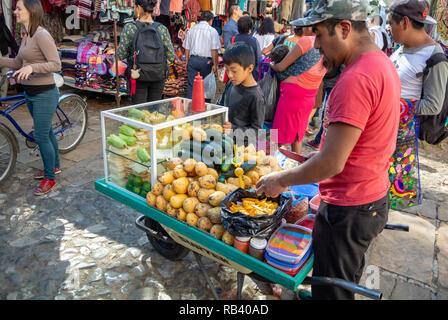 Local man selling cut fruits and vegetables in the street, San Cristobal de las Casas, Chiapas, Mexico Stock Photo