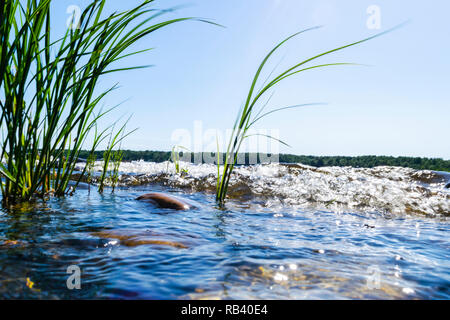 Big windy waves splashing over rocks. Wave splash in the lake against beach. Waves breaking on a stony beach, forming a spray. Water splashes. Water s Stock Photo