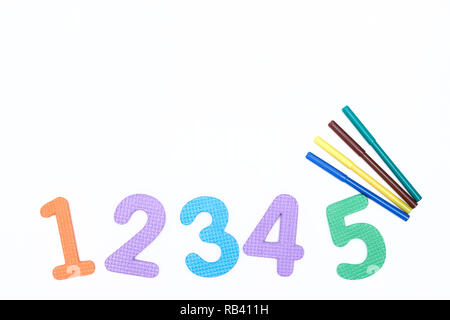 colorful markers on white background with colored numbers. children's markers for drawing. copy space. the view from the top. the concept of the school. Stock Photo