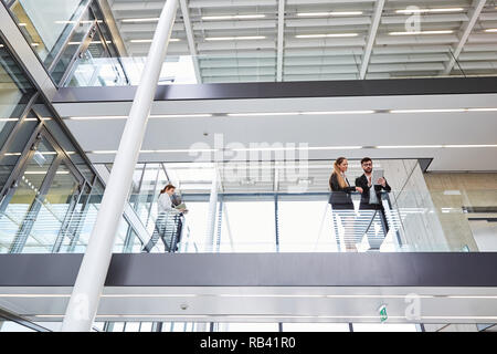 Two business people working together as a team in the modern corporate headquarters Stock Photo