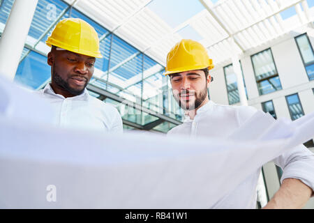 Two architects or engineers at the construction planning with a construction drawing Stock Photo