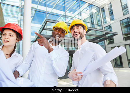 Three business people as architects in a construction planning meeting Stock Photo