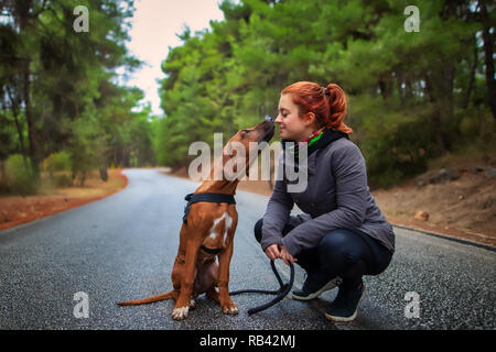 Portrait of happy teenage girl and Rhodesian ridgeback dog . Dog giving girl sweet kiss lick. Love animals love my pet Stock Photo