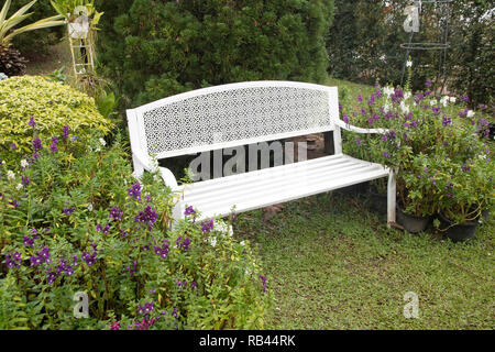Beautiful white vintage iron bench in the garden Stock Photo
