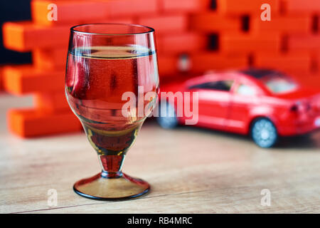 Drunk driving car crash accident. Don't drive after drink concept. Shot glass and broken car Stock Photo