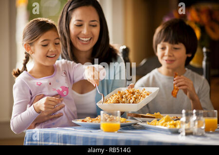 Happy family having fun eating at a dining table. Stock Photo