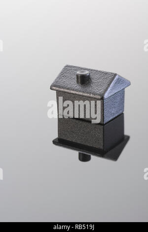 Toy black house on shiny background. Mortgages, rentals, rent arrears, repossessions, negative equity, property ladder, Housing Crisis, home ownership Stock Photo