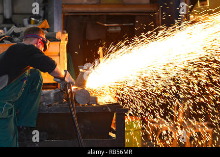 workers in safety clothing sanding a casting in an industrial company Stock Photo