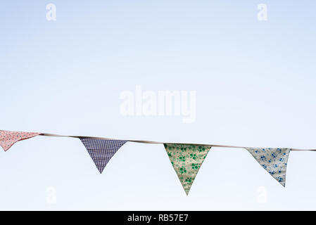 Vintage triangular pennants hanging with the blue sky in the background. Stock Photo