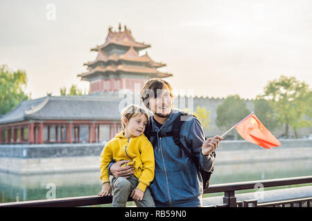 Enjoying vacation in China. Happy family with national chinese flag in Forbidden City. Travel to China with kids concept. Visa free transit 72 hours, 144 hours in China Stock Photo