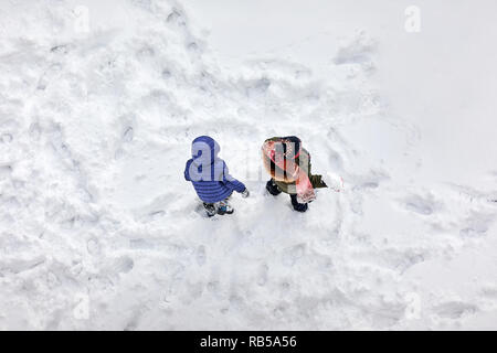 Aerial above view of two little children playing in the snow Stock Photo