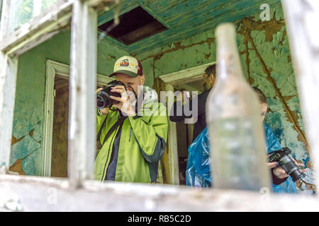 Chernobyl, Ukraine - July 2nd 2018 - Group of tourists taking pictures of the left overs in Chernobyl area, the city became famous after the nuclear i Stock Photo